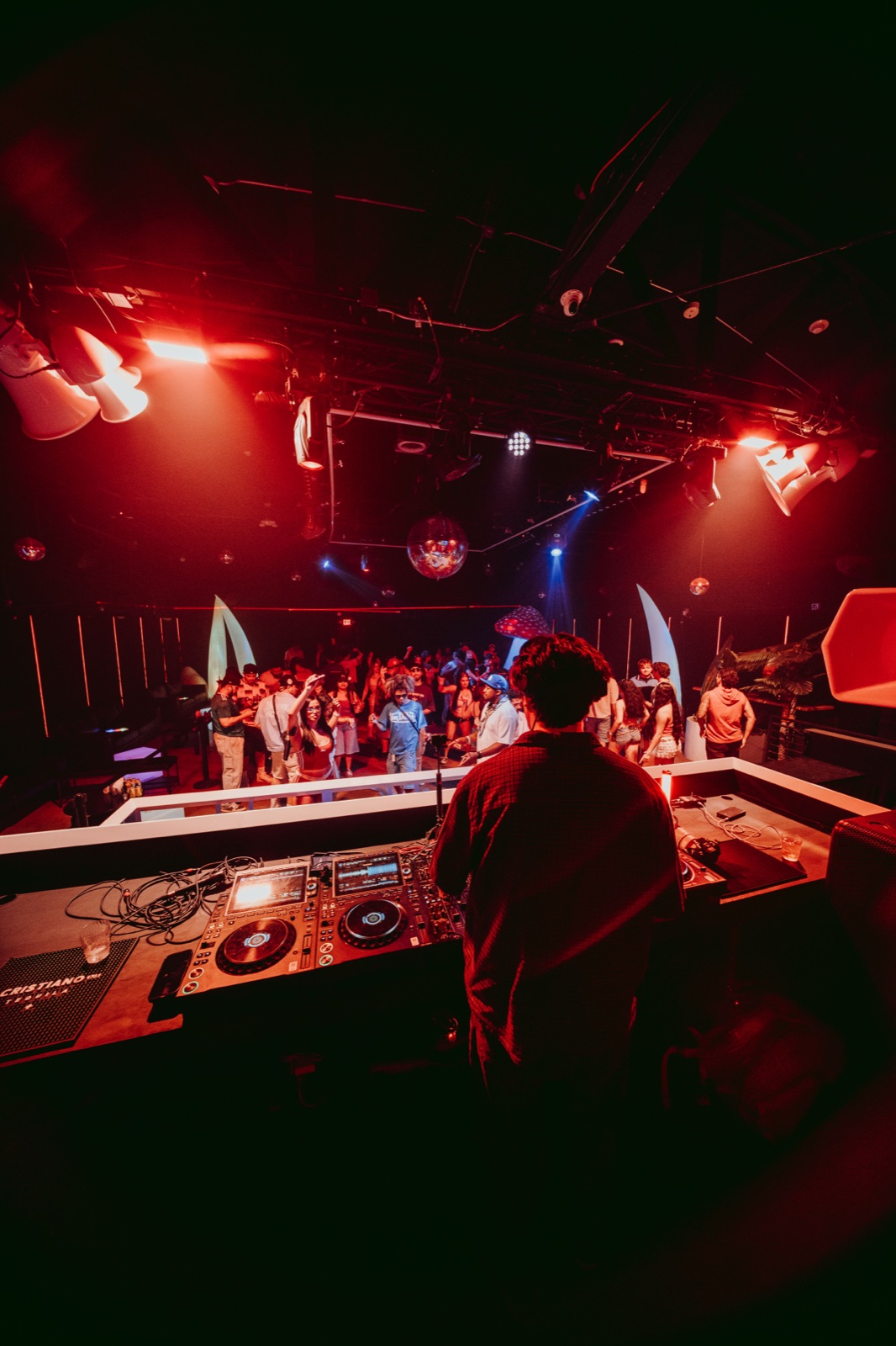 View from the DJ booth over a packed crowd on the dance floor
