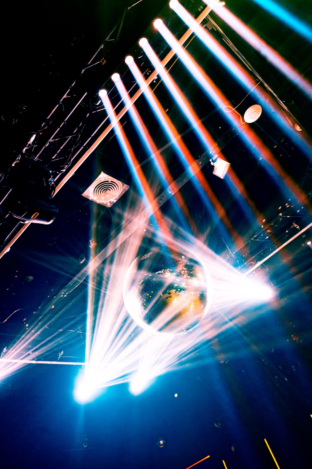 Disco ball throwing colorful light beams across the ceiling