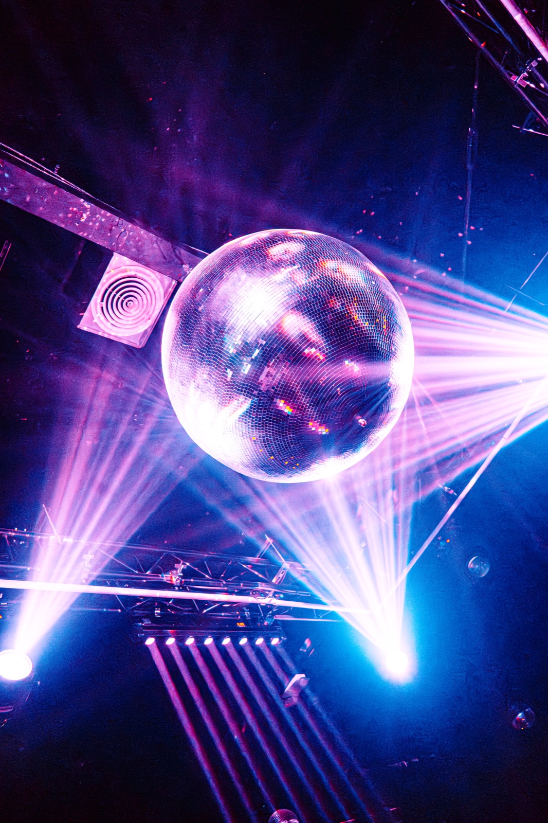 Disco ball throwing red and blue light beams across the room