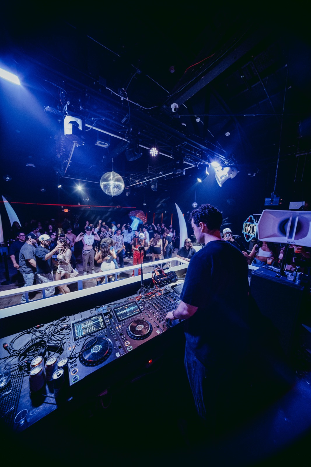 DJ booth overlooking the crowded dance floor under blue light