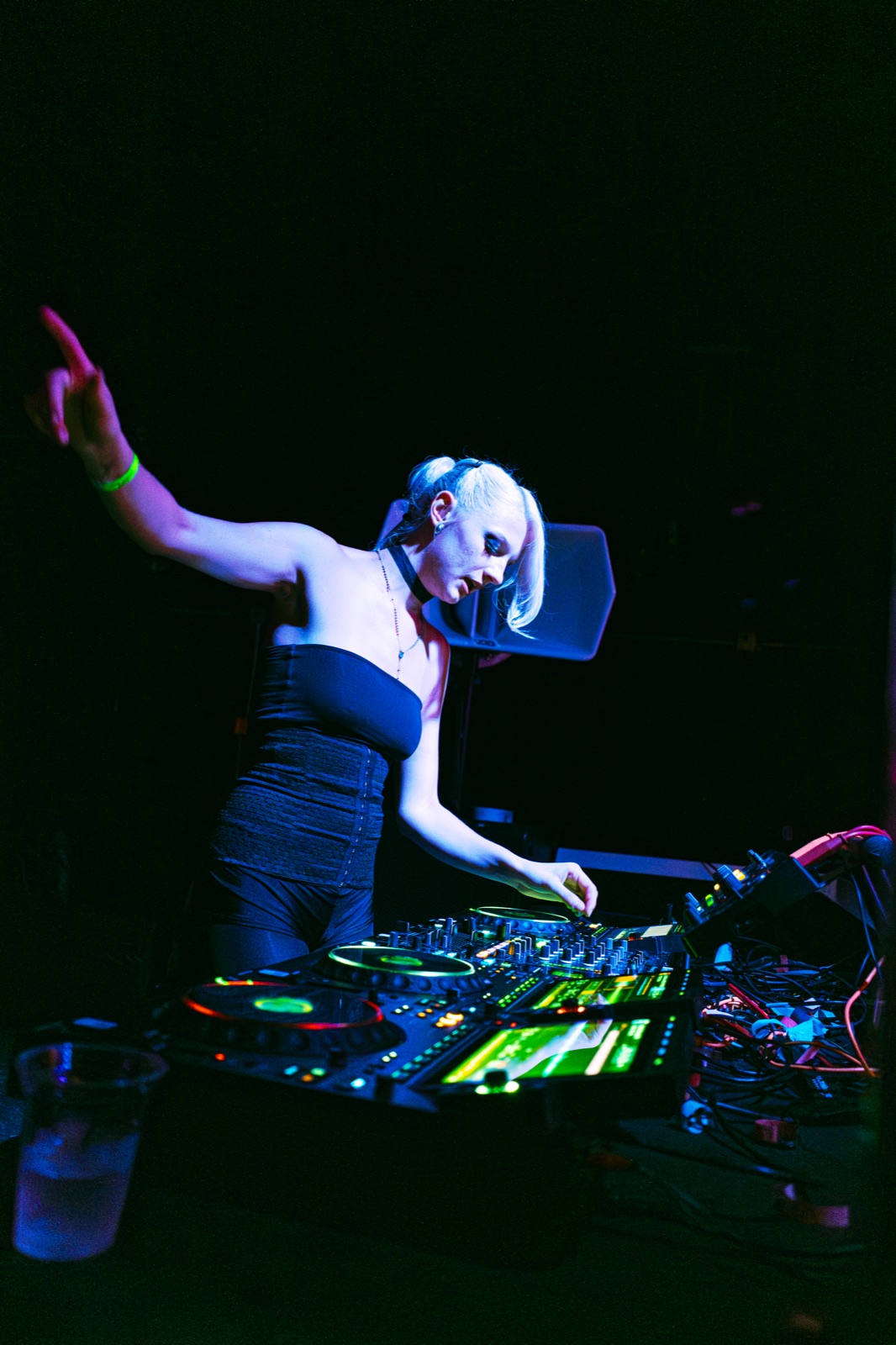 DJ performing on the elevated stage under blue lighting