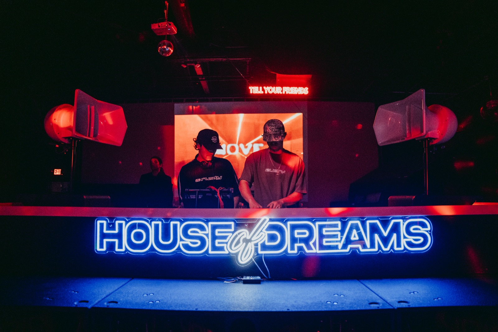 DJs performing under the House of Dreams neon sign on the elevated stage