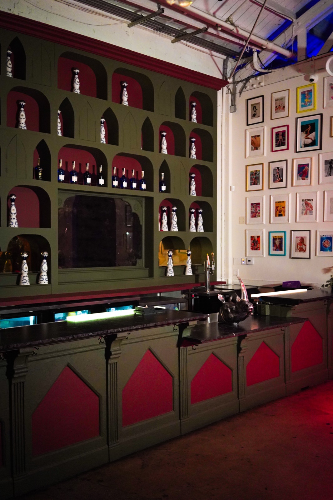 Full bar with arched bottle shelving and framed art wall