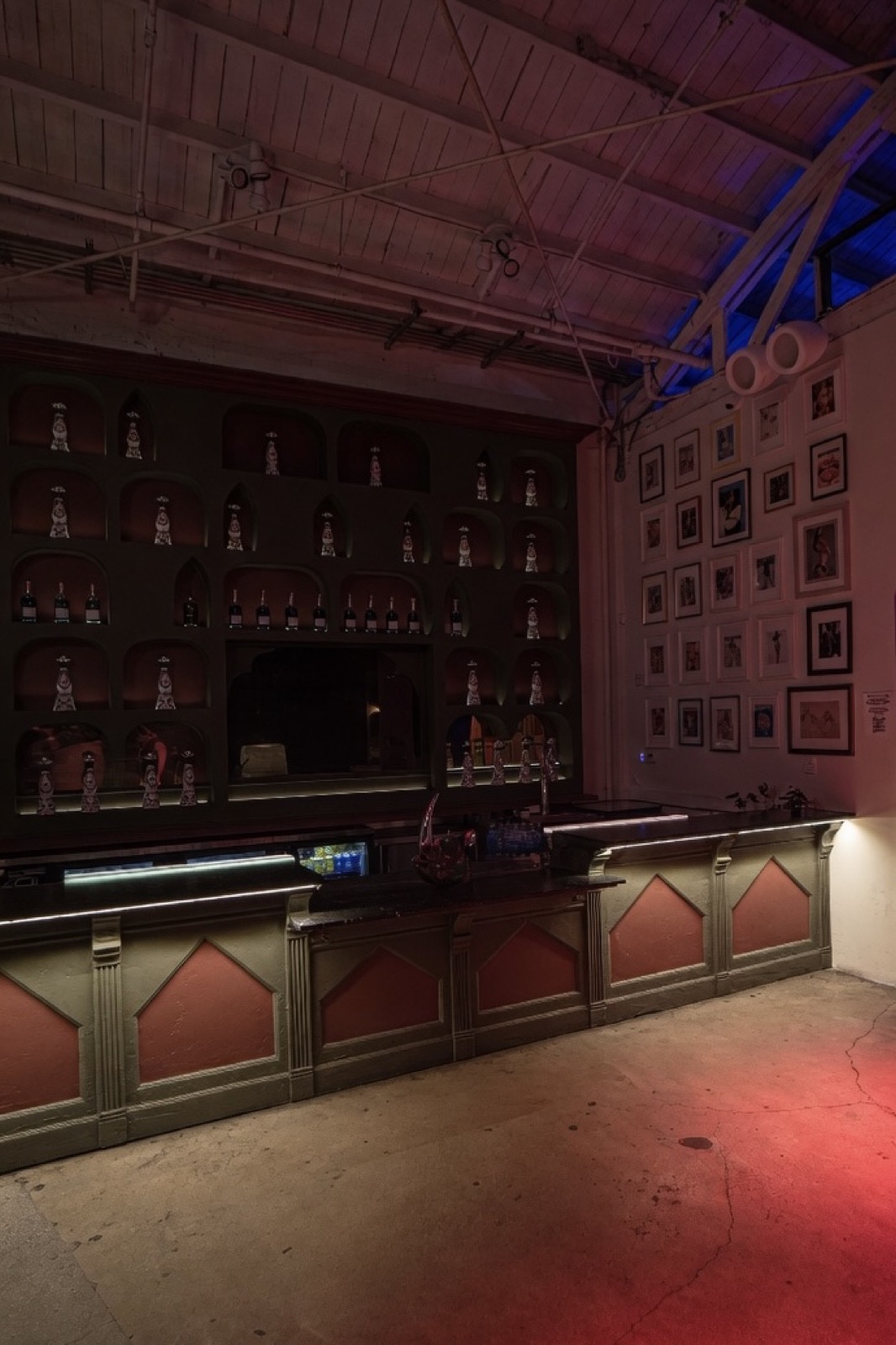 Bar area glowing in red light with framed art wall