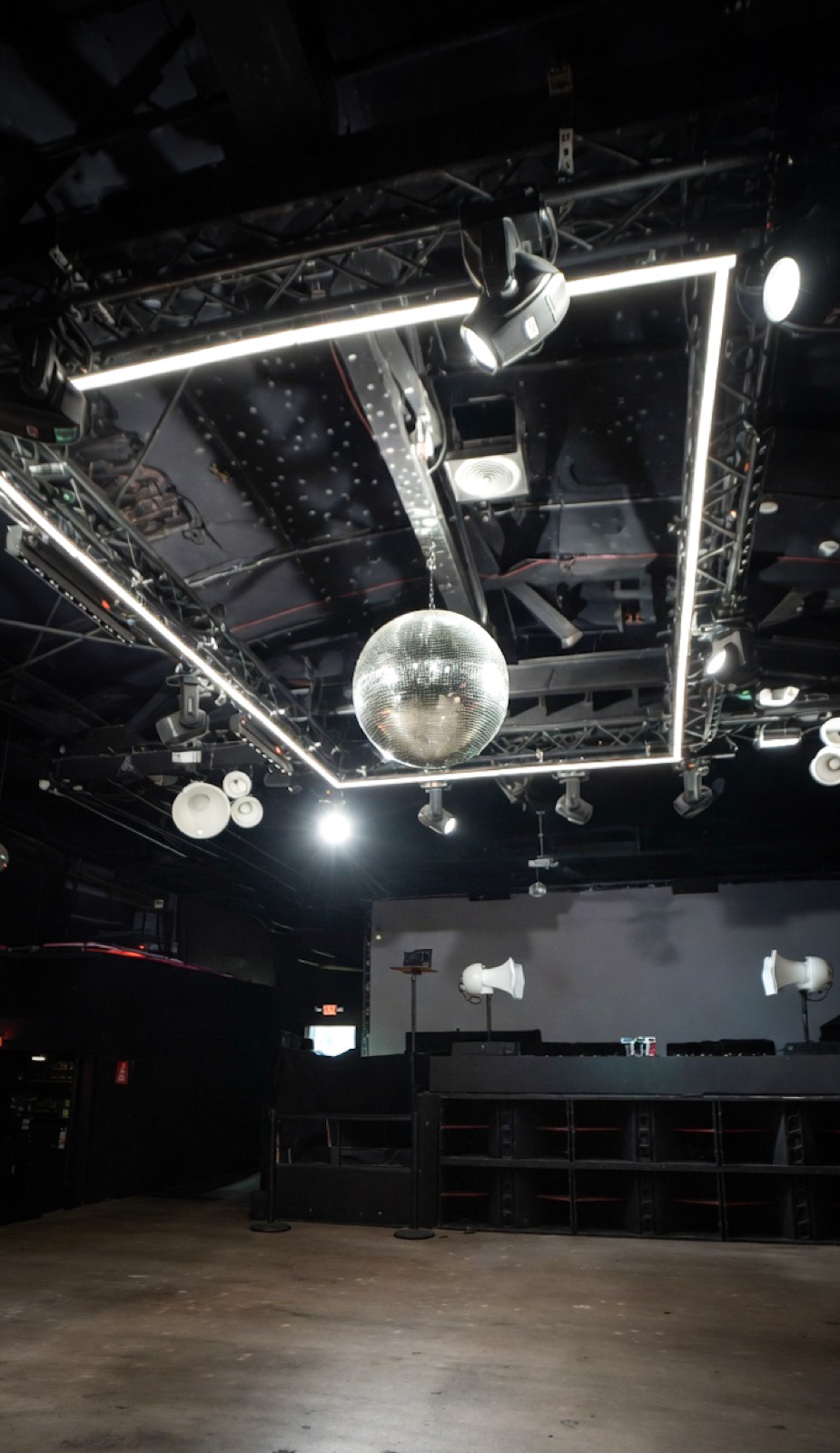 Dance floor bathed in purple light beneath the disco ball